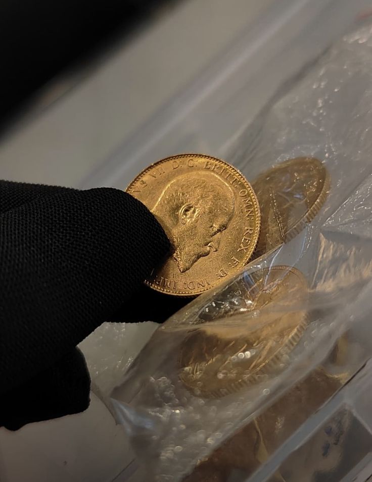 Moneda de oro sostenida con guante